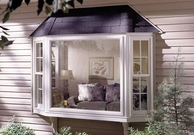 Interior view of white bay windows overlooking garden flowers